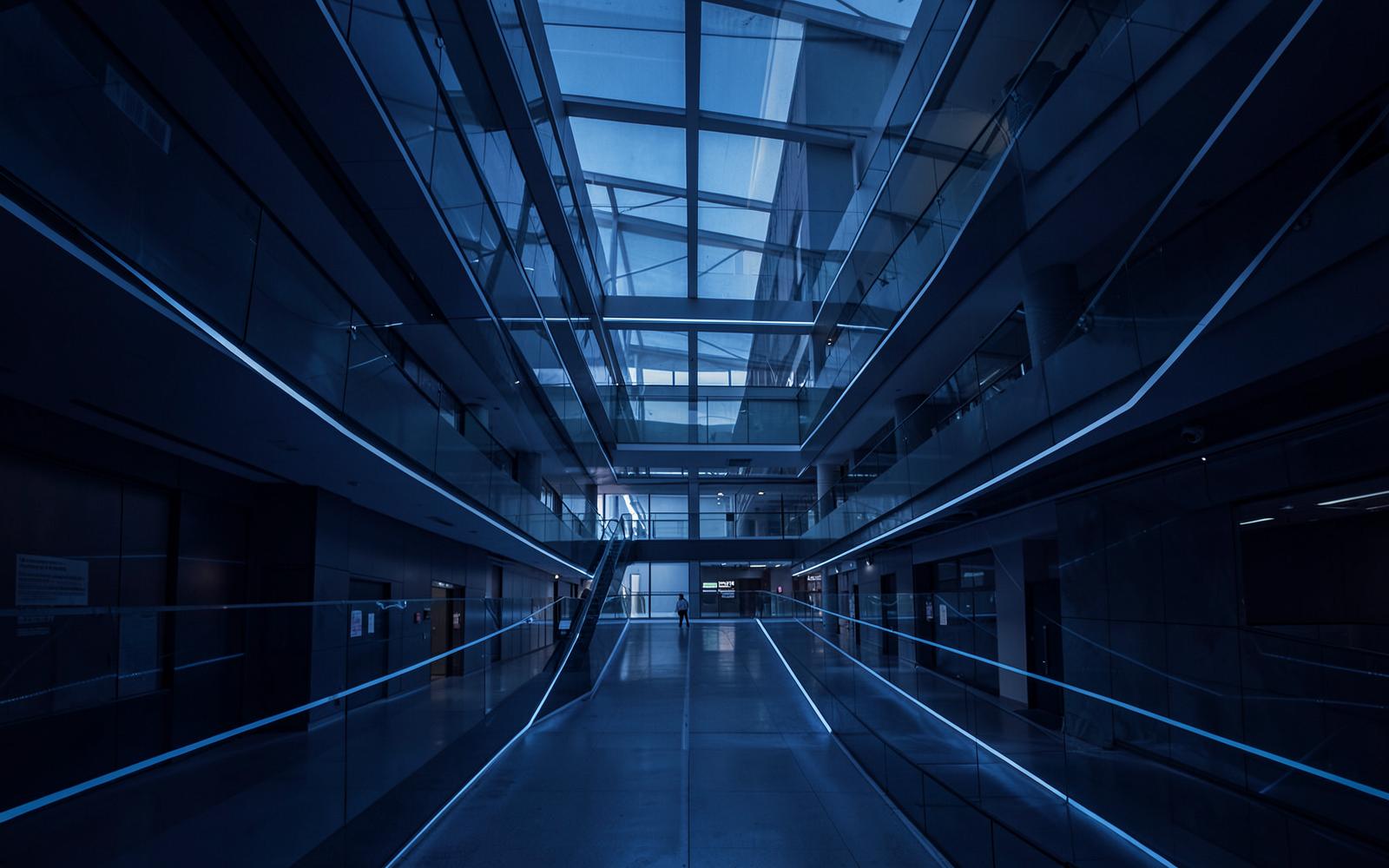 Abstract architectural structure of connected steel and glass forms, used as editorial imagery for writing about systems.